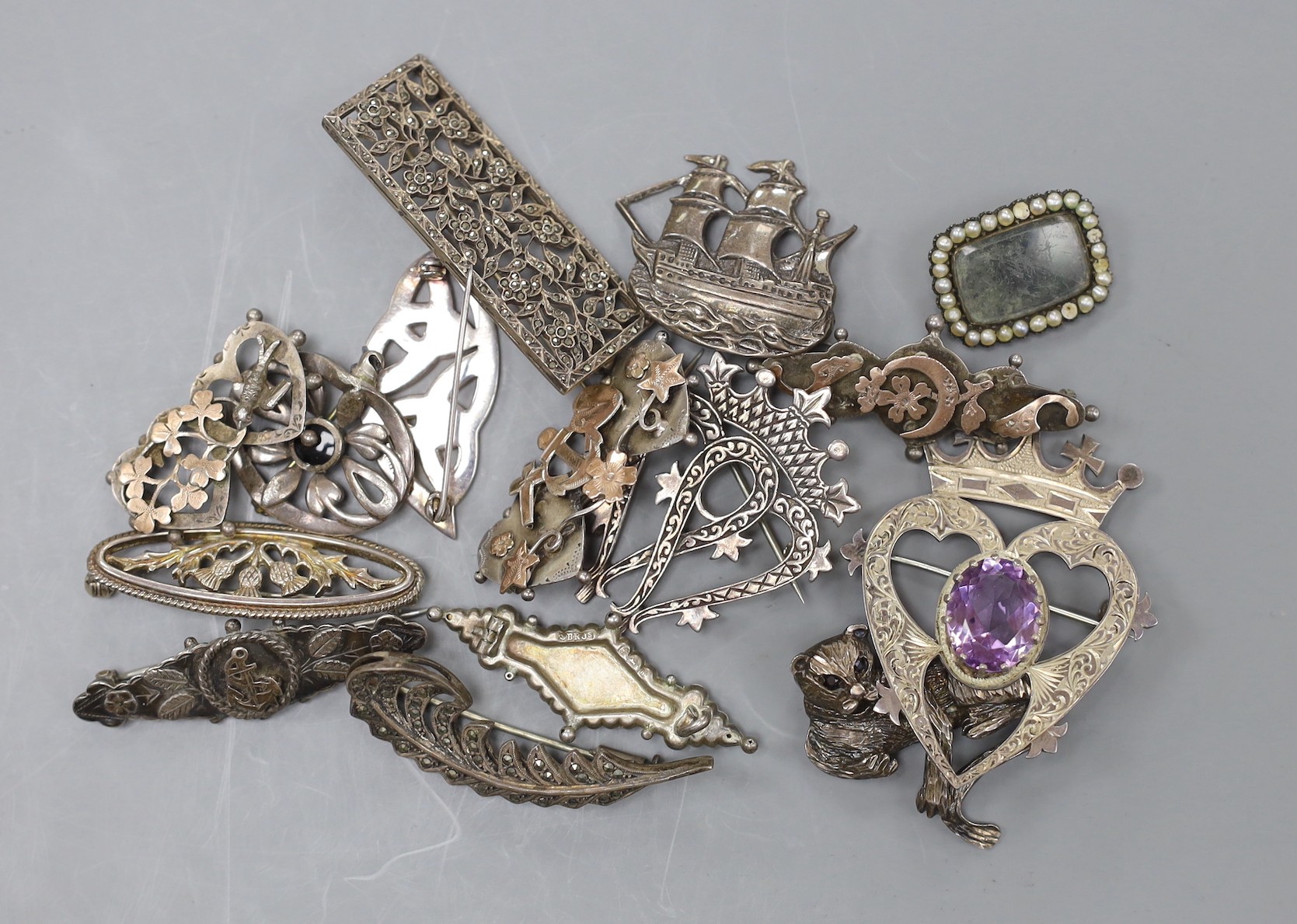 Eight assorted Victorian and later silver brooches, including part yellow metal and one heart shape set with amethyst, 52mm, together with seven other brooches including white metal and a mourning brooch.